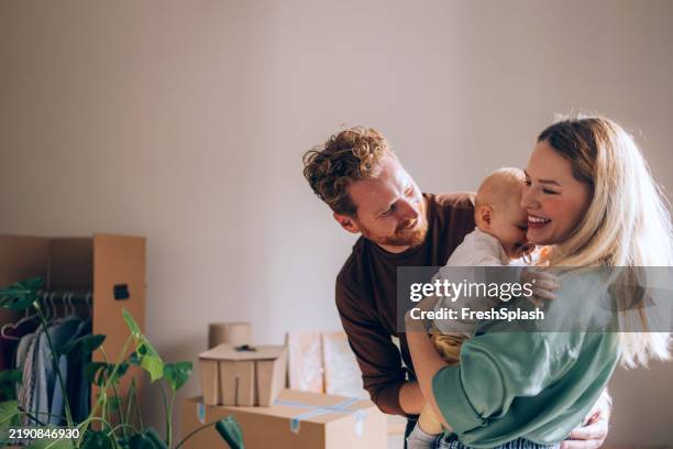 happy family moving into new home and celebrating together - uitpakken activiteit stockfoto's en -beelden
