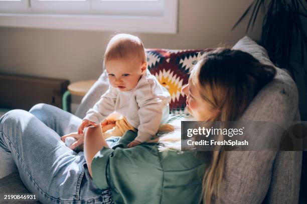 mutter und baby verbinden sich zu hause im natürlichen tageslicht - warmes licht stock-fotos und bilder