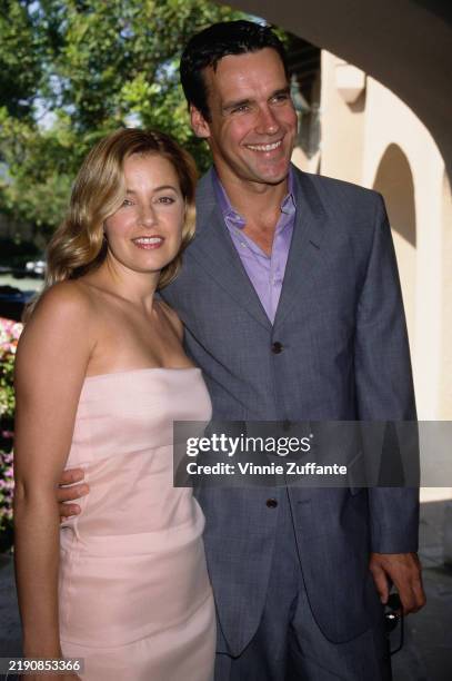 Canadian actor David James Elliott, wearing a grey blazer over a lilac shirt, and his wife, American actress Nanci Chambers, who wears a pale pink...