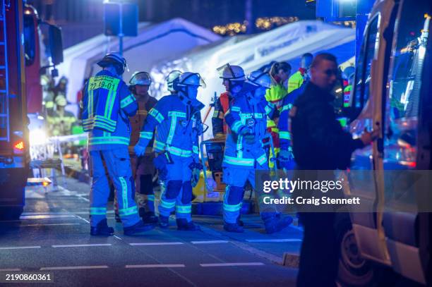 Police vans and ambulances stand next to the annual Christmas market in the city center following a possible terror incident on December 20, 2024 in...