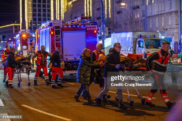 Ambulance crews ferry the injured on stretchers away from the annual Christmas market in the city center following a likely terror attack on December...