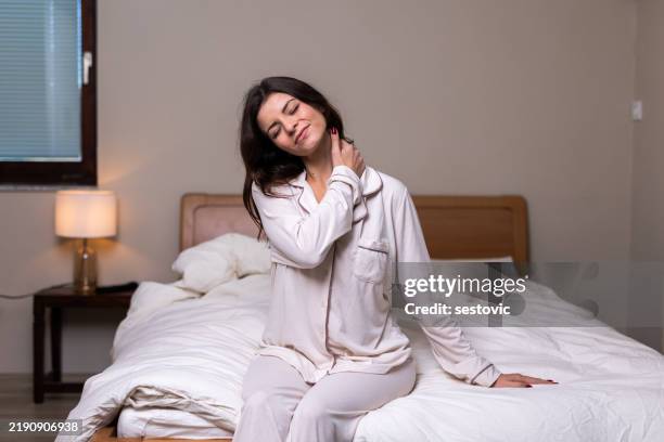 mujer que sufre dolor de cuello en una cama incómoda - fibromialgia fotografías e imágenes de stock