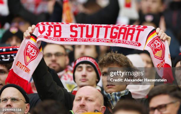 Fan of VfB Stuttgart holds up a scarf, showing support for VfB Stuttgart, prior to the Bundesliga match between VfB Stuttgart and FC St. Pauli 1910...