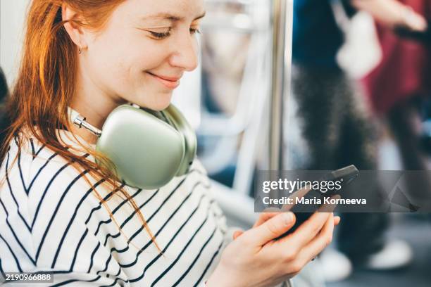 a woman uses a smartphone on a bus. - public transportation stock pictures, royalty-free photos & images