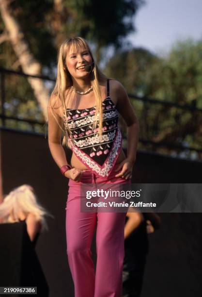 American singer and actress Hoku, wearing a pink, black and white cropped top and pink trousers, performing live on stage at the KIIS FM 102 7...