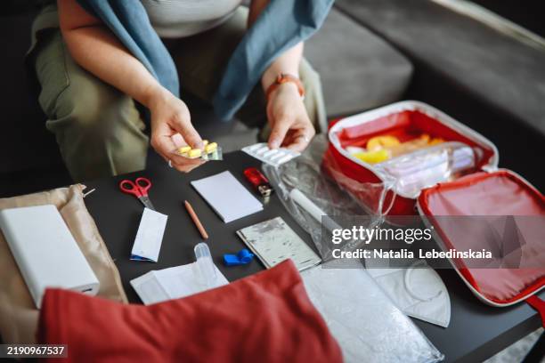 plus-size unrecognisable woman organizing medicines in a doomsday prepping kit at home, preparing essential supplies for emergencies. - emergency kit flat lay stock pictures, royalty-free photos & images