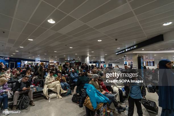 Passengers in the Manchester Airport are waiting for their flights in Terminal 3. Fog has caused significant disruption at Manchester Airport,...