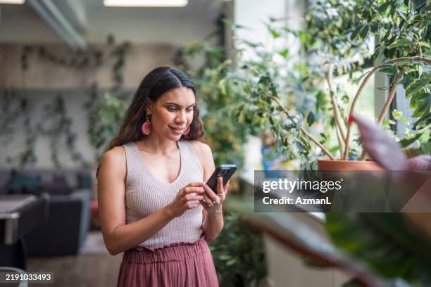 confident young aboriginal businesswoman engages with smartphone - indigenous stock pictures, royalty-free photos & images