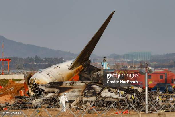 Fire authorities search for the missing and recover the deceased at the site of an accident near Muan International Airport in Jeollanam-do, South...