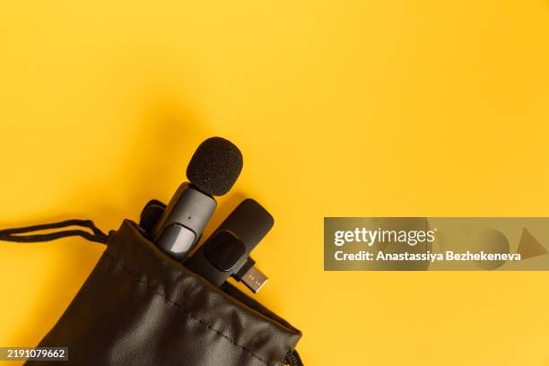 lavalier microphone with receiver in a leather bag on a yellow background - solapa fotografías e imágenes de stock