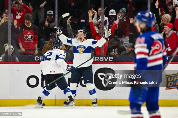 Tuomas Uronen of Team Finland celebrates his overtime goal with teammate Mitja Jokinen against Team USA of the Group A match during the 2025 IIHF...
