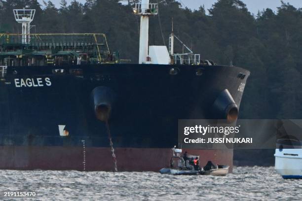 Officers of the Finnish Coast Guard stop a small boat which tried to reach the oil tanker Eagle S anchored near the Kilpilahti port in Porvoo, on the...