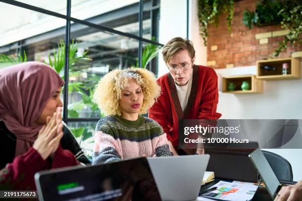 business colleagues looking at laptop and discussing in meeting - voile religieux photos et images de collection