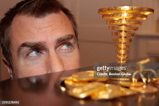 Belmont, MA Meteorologist Dan Leonard poses with the trophy/statue he found in the woods during a treasure hunt, and the $87,600 prize in gold coins.