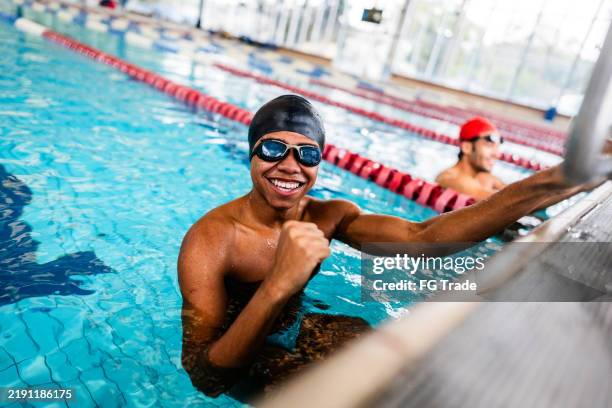 portrait of a young man in the swimming pool - zwemmer stockfoto's en -beelden
