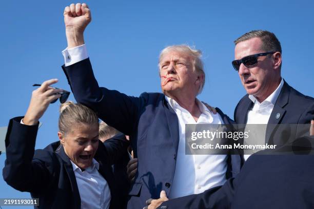 Republican presidential candidate former President Donald Trump defiantly pumps his fist after being shot and rushed offstage during a rally on July...