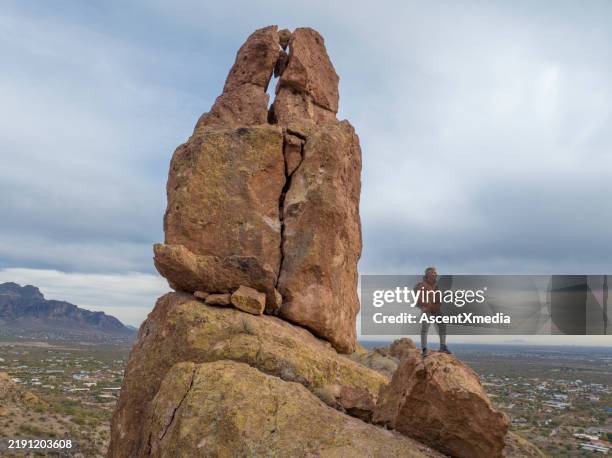 aerial view of hiker pausing on rock below spire - aguja chapitel fotografías e imágenes de stock