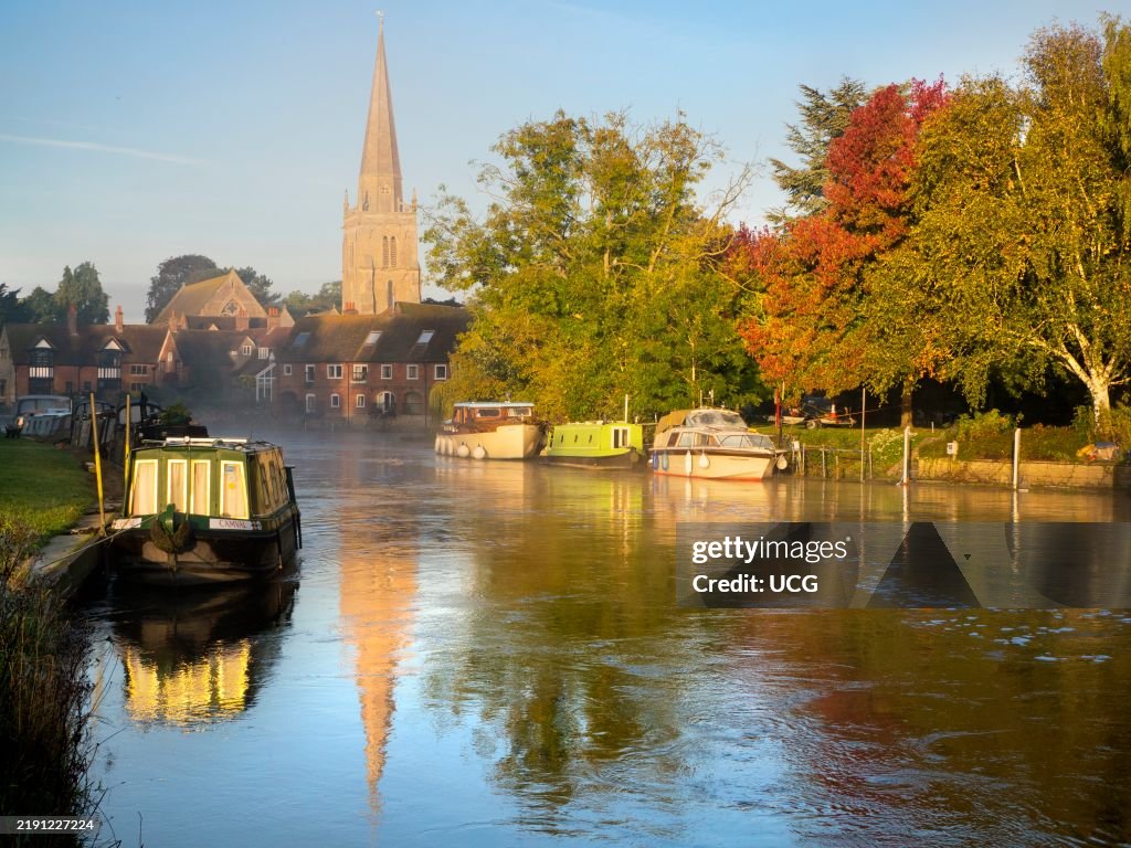 St Helens Church and houseboats on the Thames at Abingdon, early on a misty Autumn morning
