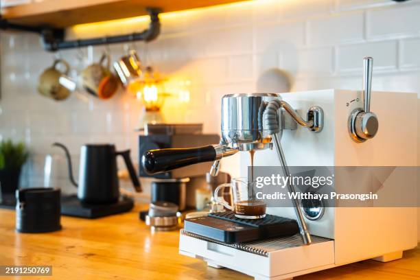 modern espresso machine brewing coffee in a stylish kitchen setting - koffiemachine stockfoto's en -beelden