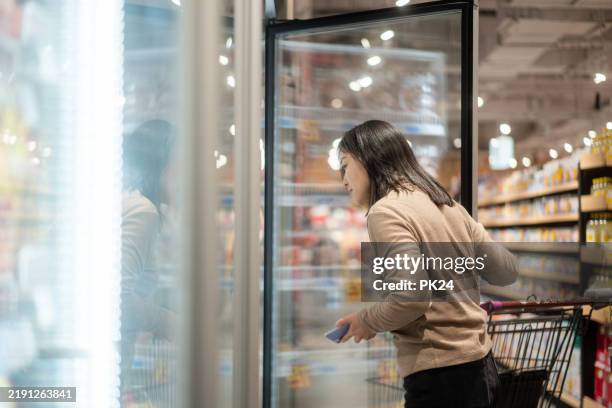 compras femeninas asiáticas en la plataforma de hielo - estantería de productos refrigerados fotografías e imágenes de stock