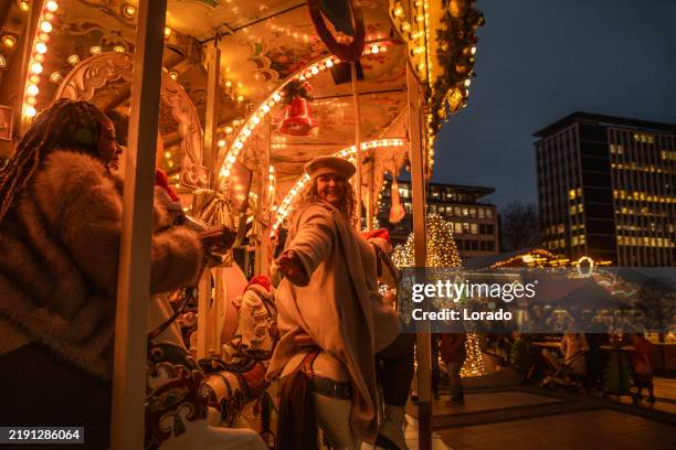 lifestyle-shooting eines schönen gemischtrassigen paares mit freundinnen auf einem weihnachtsmarkt - weihnachtsmarkt stock-fotos und bilder