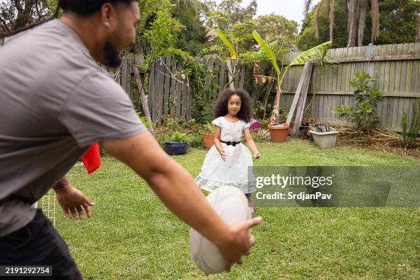pacific islander brother and sister playing rugby in their back yard - polynesian ethnicity stock pictures, royalty-free photos & images