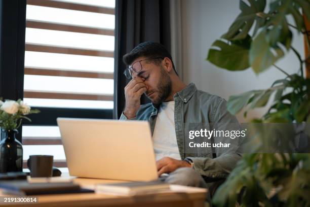 stressed businessman having headache while working from home office - eye strain at work stock pictures, royalty-free photos & images