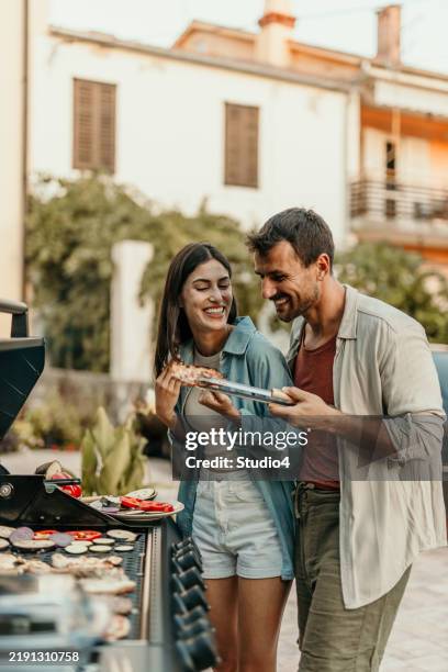 couple prepare bbq in the yard - grilled stock pictures, royalty-free photos & images
