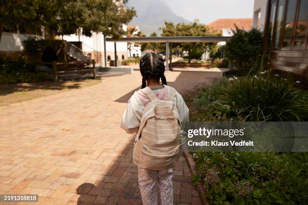 rear view of schoolgirl standing on footpath - flagstone elementary school stock pictures, royalty-free photos & images