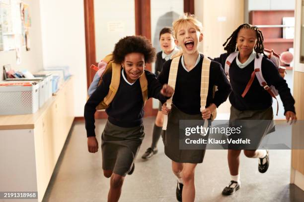 carefree students running on school premises - school uniform stock pictures, royalty-free photos & images