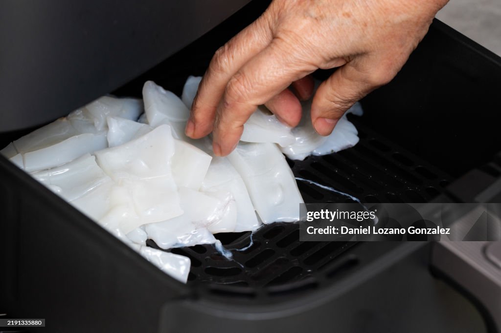 Chef arranging squid in air fryer for healthy cooking
