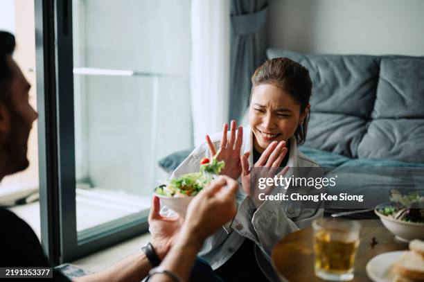 asiatische malaiinnen weigern sich, frischen salat zu essen. - verweigern stock-fotos und bilder