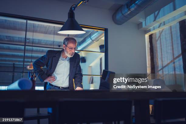 business executive working late in modern office - cfo stock pictures, royalty-free photos & images