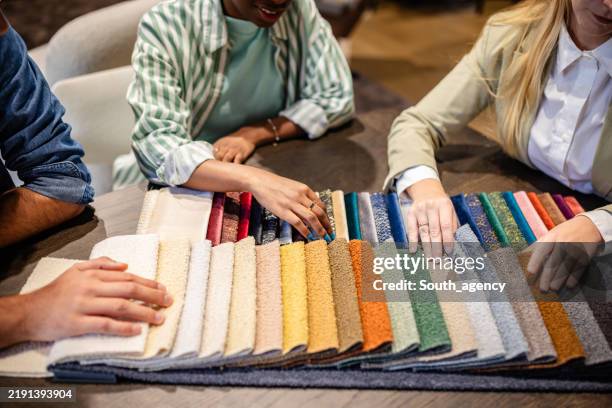 hands exploring colorful textile options on table - picking teams stock pictures, royalty-free photos & images