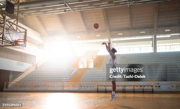 young basketball player practicing free throws alone on the court - arremessar imagens e fotografias de stock