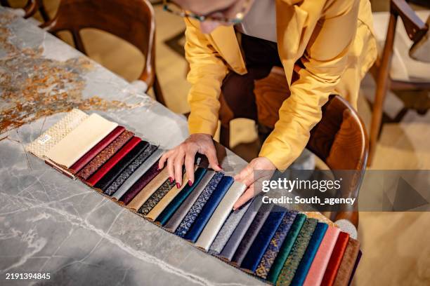 designer reviewing fabric samples on marble surface - fabric swatch stock pictures, royalty-free photos & images