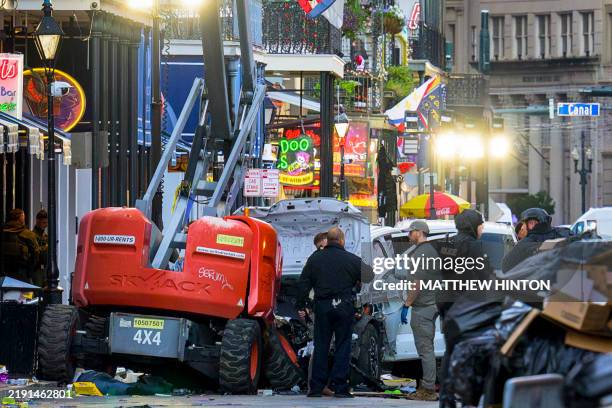 Graphic content / Police investigators surround the white Ford F-150 pickup truck that crashed into a work lift after allegedly driving into a crowd...