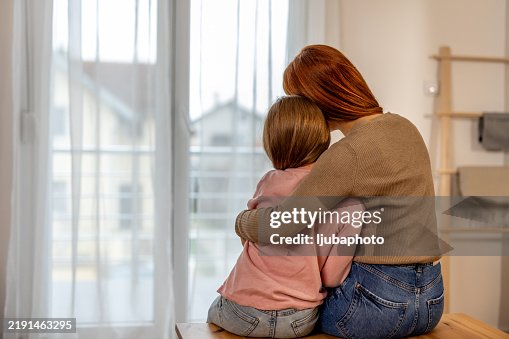 Mother Comforting Daughter by Embracing Her in a Home Setting Mother Comforting Daughter by Embracing Her in a Home Setting