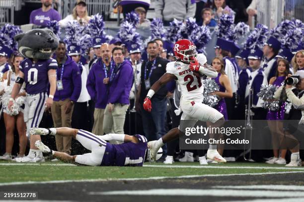 Running back Antwan Raymond of the Rutgers Scarlet Knights runs past cornerback Keenan Garber of the Kansas State Wildcats to score a touchdown...