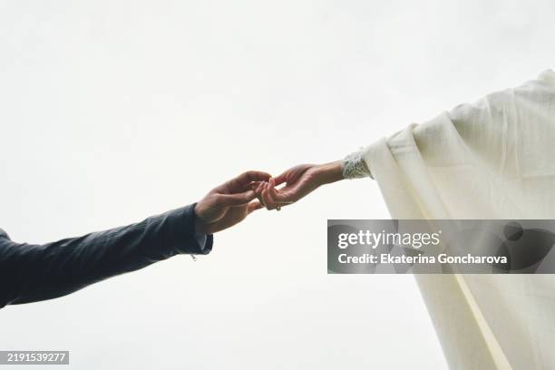 hands reaching out symbolizing connection and human bonds captured in soft light - hand patting stock pictures, royalty-free photos & images