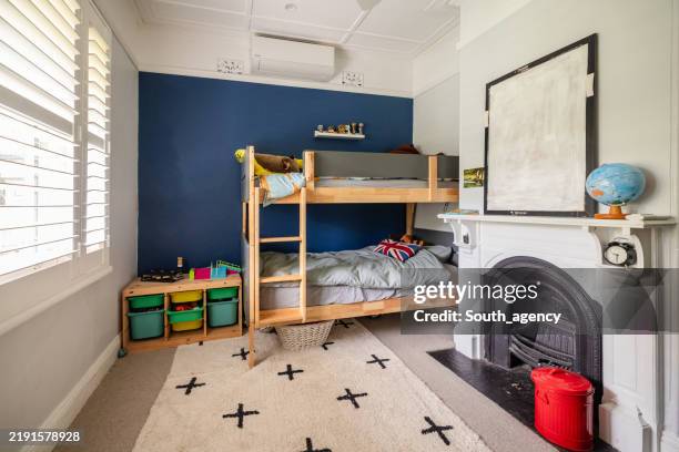 kids room with blue accent wall and bunk beds setup. - bunkbed stock pictures, royalty-free photos & images