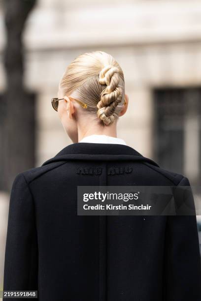 Yulia Lobova - Harfouch wears a Miu Miu coat and a twist in her hair outside the Miu Miu show during Womenswear Spring/Summer 2025 as part of Paris...
