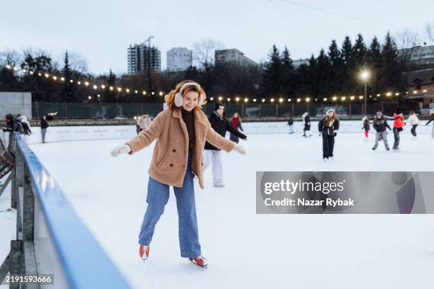 la donna gioiosa che pattina sulla pista di pattinaggio in inverno - pista di pattinaggio su ghiaccio foto e immagini stock