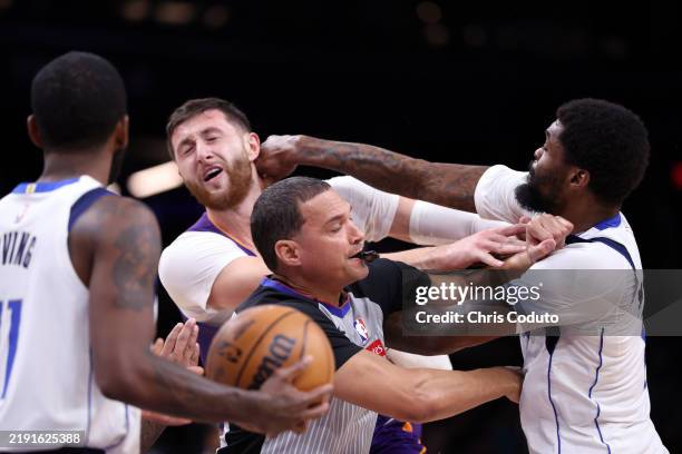 Naji Marshall of the Dallas Mavericks punches Jusuf Nurkic of the Phoenix Suns during the second half at Footprint Center on December 27, 2024 in...