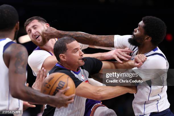 Naji Marshall of the Dallas Mavericks punches Jusuf Nurkic of the Phoenix Suns during the second half at Footprint Center on December 27, 2024 in...