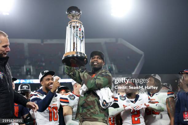 Head coach Fran Brown of the Syracuse Orange holds the championship trophy for the DirecTV Holiday Bowl after defeating Washington State Cougars...