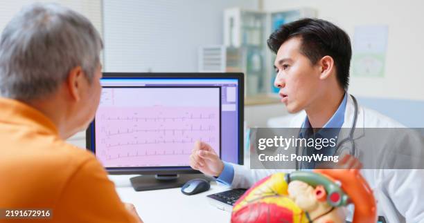 doctor explain cardiologist exam - hartritmestoornis stockfoto's en -beelden