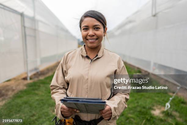 portrait of a farmer worker using digital tablet on a greenhouse - biologist stock pictures, royalty-free photos & images
