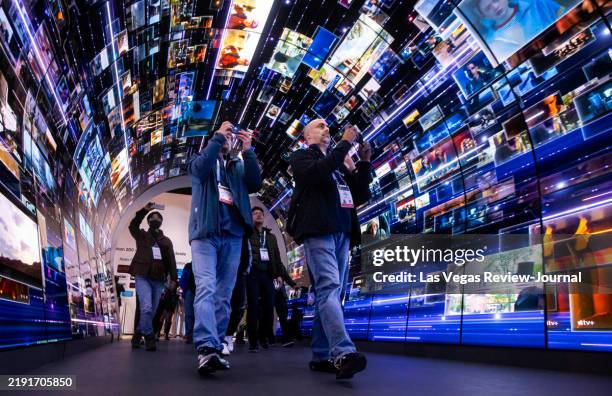 Attendees walk through an installation highlighting LG Electronics' webOS smart TV platform during the first day of CES at the Las Vegas...