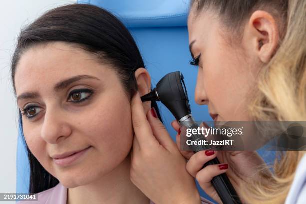 woman doctor getting ear exam at clinic. - hearing test stock pictures, royalty-free photos & images